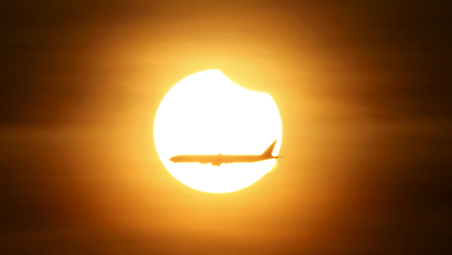 An airplane flying past the sun