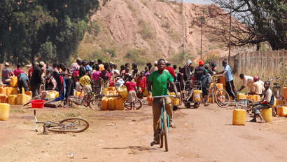People fetch water outside a copper and cobalt mine run by Sicomines in Kolwezi, Democratic Republic of Congo, May 30, 2015.