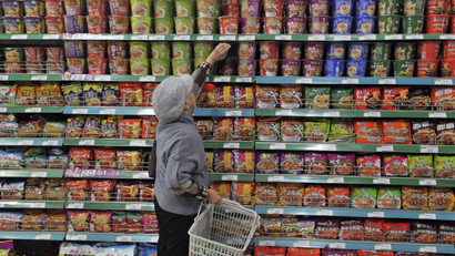 A customer selects instant noodles at a supermarket in Yinchuan