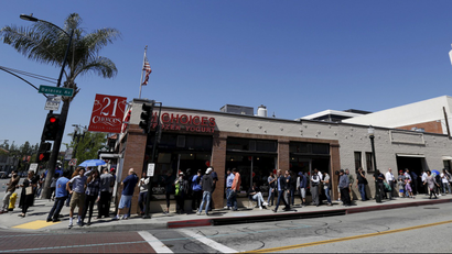 People wait in line near a Tesla Motors store to place deposits on the electric car company's mid-priced Model 3 which is expected to cost around $35,000 in Pasadena.