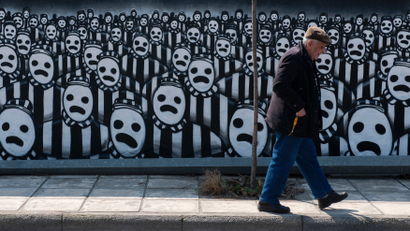 A man walks past a graffiti dedicated to the Holocaust in the northern port city of Thessaloniki March 15, 2015. Jews gathered at the northern town of Greece for an event organised by the Thessaloniki Jewish community marking the first deportation of Thessaloniki Jews to Nazi death camps during World War Two. REUTERS/Alexandros Avramidis (GREECE - Tags: ANNIVERSARY SOCIETY POLITICS TPX IMAGES OF THE DAY CONFLICT) - RTR4TFC5