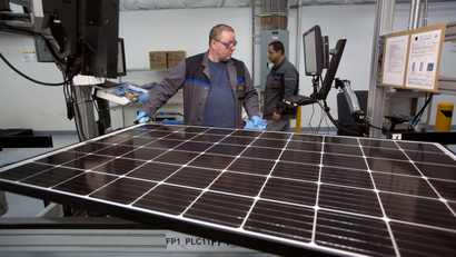 Production operator John White checks a panel at the SolarWorld solar panel factory in Hillsboro, Oregon