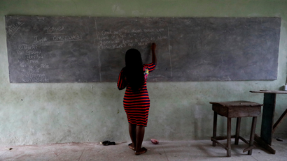 A teacher writes on a chalk board as she teaches a class at Ilorin Grammar School, in Ilorin, Kwara state, March 24, 2021.