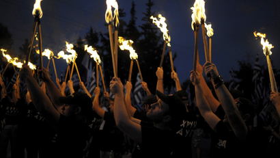Golden Dawn supporters lift torches as they take part in a ceremony in Thermopylae