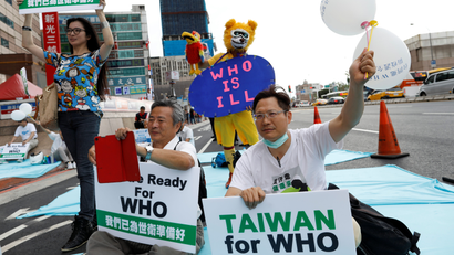 Protesters hold signs in favor of Taiwan becoming part of the WHO.