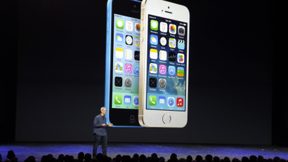 Tim Cook on stage against a backdrop of iPhone 5s and 5c