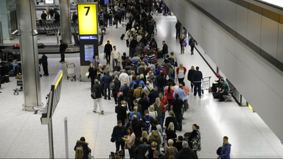 People queue in the luggage hall of Terminal 5 at Heathrow Airport in London, Friday, Dec. 12, 2014.