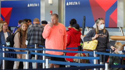 Travelers line up at a Delta Air Lines gate at the airport.
