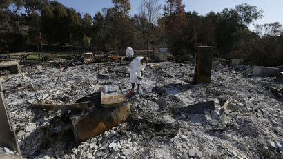 Residents search the remains of homes destroyed by wildfire