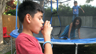 In this April 4, 2017 photo, Javier Sua demonstrates how he uses an inhaler at his home in Fresno, Calif. He uses it to combat asthma, made worse by air pollution in the San Joaquin Valley. On some days, his mother keeps him inside, when he would rather be rough-housing on the backyard trampoline, but the risks are too high. Hundreds of people each year in the San Joaquin Valley die premature deaths from poor air quality.