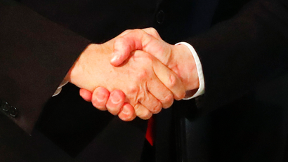 two white men in suits shaking hands