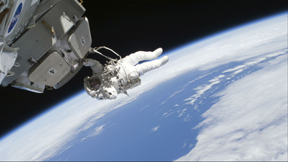 An astronaut working on a spacecraft above Earth.