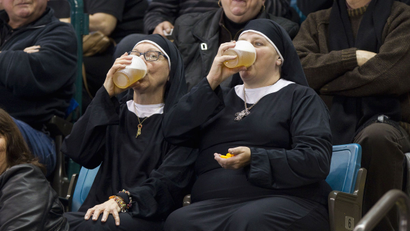 Two women dressed as nuns drink beer.