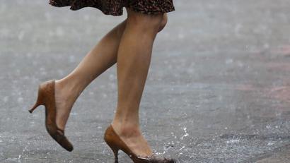 A woman walks in heavy rain
