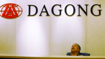 A man naps at the front desk in the headquarters of Dagong Global Credit Rating Co., Ltd. in Beijing, China, 28 July 2011. Chinas Dagong Global Credit Rating has cut its credit rating on U.S. sovereign debt to A from A+, according to Chen Jialin, general manager of the international department at the company. The agency has also put the U.S. on negative outlook.(Imaginechina via AP Images