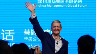 Apple CEO Tim Cook waves as he attends a talk in Beijing October 23, 2014.