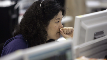 A call centre personnel presses her fist to her mouth at an online brokerage company in Tokyo