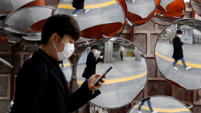 A man wearing a mask to prevent the coronavirus is reflected in the mirrors, in Seoul, South Korea, February 24, 2020.