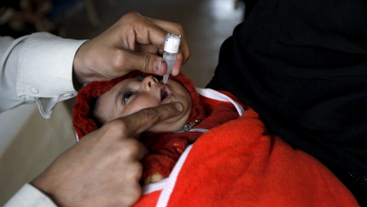 A baby girl receives polio vaccine drops