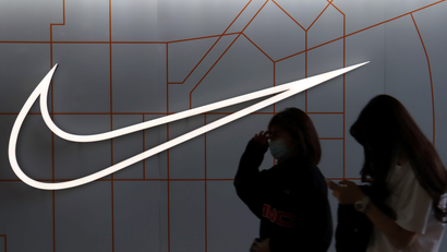 People walk past a store of the sporting goods retailer Nike Inc at a shopping complex in Beijing