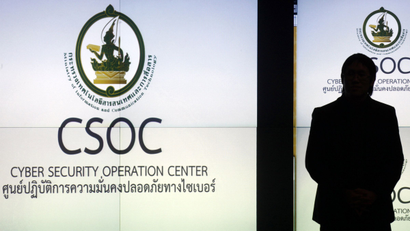 A man is silhouetted against a screen at the cyber security operation centre in Bangkok
