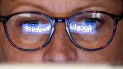 The Facebook logo is reflected on a woman's glasses in this photo illustration taken June 3, 2018. REUTERS/Regis Duvignau/Illustration - RC13DB520D70