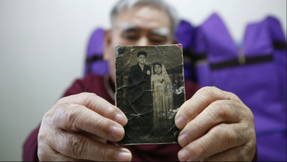 A South Korean man holds up a photo of his younger brother, a North Korean.