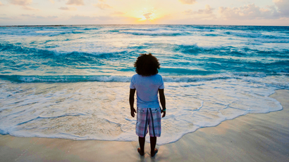 A man watches the sunrise on New Year's Day at Gaviota Azul beach in Cancun.