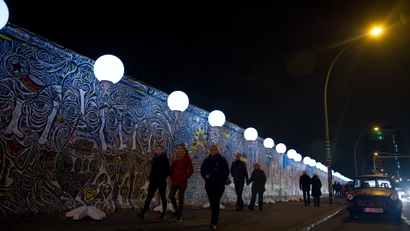 People walking along the Berlin Wall's remains