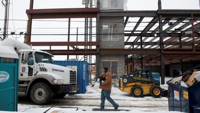 A worker walked buy a construction zone and a truck in downtown Erie, Pennsylvania.