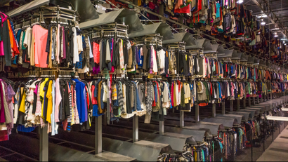A warehouse containing racks full of used clothes