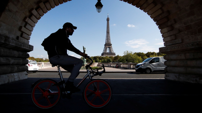 A man rides a bike-sharing service mobike bicycle at the Pont de Bir-Hakeim birdge near the Eiffel Tower in Pairs