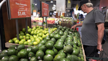 A man shops for avocados at a Whole Foods Market, in New York.