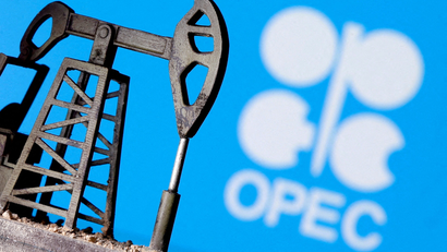 A 3D-printed oil pump jack is seen in front of displayed OPEC logo.