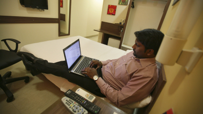 A guest works on a laptop inside his room at the Tata Group's Indian Hotels Co. Ginger chain in Ahmedabad
