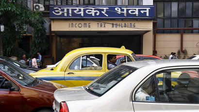 Commuters sit in cars in front of the income tax building during a traffic jam in Kolkata