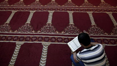 A Muslim faithful reads the Koran in Greece