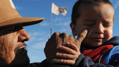 A man named Black Horse holds his grandson during a protest against the Dakota Access pipeline near the Standing Rock Indian Reservation