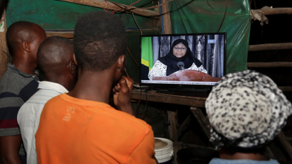 Residents watch the announcement of the death of Tanzania's president John Magufuli, addressed by vice president Samia Suluhu Hassan in Dar es Salaam, Tanzania.