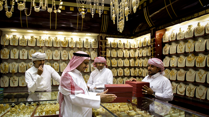 Muslim men sell gold in a shop in Dubai