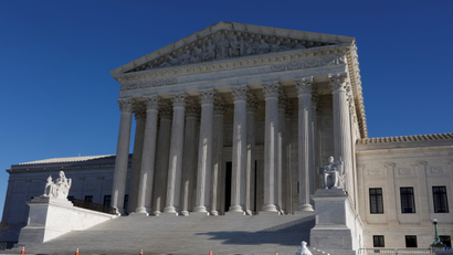 The marble pillars of the US Supreme Court building on a clear blue day.