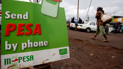 A woman walks past a sign advertising Safaricom mobile money called MPESA in the high density suburb of Kangami in Nairobi, Kenya on 26 March 2008. The Kenyan government plans to sell 25 per cent of its stake in the highly profitable mobile operator Safaricom by holding east Africa's largest ever IPO which is scheduled to begin selling shares on 28 December 2008.