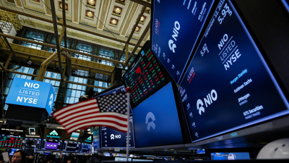 An American flag is seen among logos for Chinese electric vehicle start-up NIO Inc., on the trading floor of the New York Stock Exchange