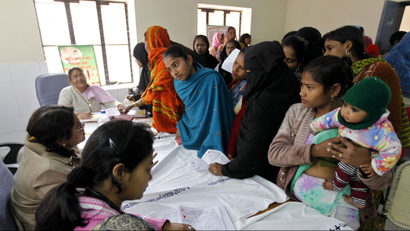 In this Feb. 4, 2011 photo, patients get registered for a free sterilization procedure at the Mohan Lal Gautam District Women's Hospital in Aligarh, India. Every day dozens of women line up at this hospital for a free sterilization procedure that will spare them the risk and cost of having another child. The hospital's three staff doctors race through seeing some 500 patients a day needing help with childbirth, pelvic inflammatory diseases, abortions and other treatments at subsidized costs. Each year, the cost of health care pushes some 39 million people into poverty, with patients shouldering up to 80 percent of India's medical costs. (AP Photo/Mustafa Quraishi