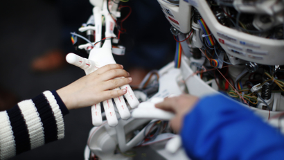 Children touch the hands of the humanoid robot Roboy at the exhibition Robots on Tour in Zurich