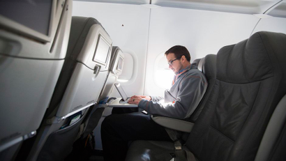 A man uses his laptop to test a new high speed inflight Internet service named Fli-Fi while on a special JetBlue media flight out of John F. Kennedy International Airport in New York
