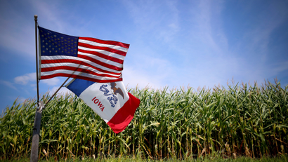 U.S. and Iowa state flags are seen next to a corn field