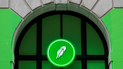 The logo of Robinhood Markets is displayed in front of a barred window on Wall Street
