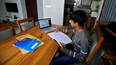 A student makes notes as he attends an online class at his home after Gujarat government ordered the closure of schools and colleges across the state amid coronavirus disease (COVID-19) fears, in Ahmedabad