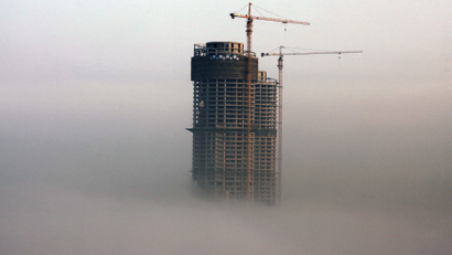 A building under construction is seen in fog in Rizhao, Shandong province, February 26, 2014. China's property market is likely to see at most a moderate correction in prices in some small cities this year, according to a Reuters straw poll of 13 industry watchers this week, with the chance of a sharp fall in prices nationwide very slim. Picture taken February 26, 2014. REUTERS/Stringer